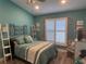 Bright bedroom with white shuttered windows, stylish wall decor, and wood-look tile flooring at 4749 Stoneview Cir, Oldsmar, FL 34677