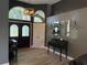 Elegant foyer with arched windows, double doors, and wood-look tile flooring at 4749 Stoneview Cir, Oldsmar, FL 34677