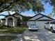 Charming two-story home with well-manicured lawn, three-car garage, and modern vehicles at 4749 Stoneview Cir, Oldsmar, FL 34677
