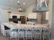 Bright kitchen features white cabinets, stainless appliances, an island with seating, and modern pendant lighting at 4749 Stoneview Cir, Oldsmar, FL 34677