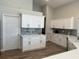 Beautiful kitchen with sleek white cabinetry, stainless steel hardware, gray backsplash, and wood-look tile flooring at 4749 Stoneview Cir, Oldsmar, FL 34677