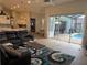 Open-concept living room with a plush black leather sofa, leading to kitchen and a patio with pool at 4749 Stoneview Cir, Oldsmar, FL 34677