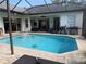 This outdoor oasis features a pool, patio with seating, and views of the backyard, perfect for entertaining at 4749 Stoneview Cir, Oldsmar, FL 34677