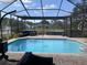 The screened-in pool area includes a beautiful pool, spa, and outdoor seating with views of a tranquil water feature at 4749 Stoneview Cir, Oldsmar, FL 34677