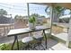 View of an outdoor screened patio with table, stools, and view of the backyard at 7226 13Th N St, St Petersburg, FL 33702