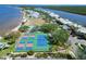 Aerial view of tennis and pickleball courts, pool, and waterfront condos near the beach at 603 Bahia Beach Blvd, Ruskin, FL 33570