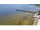 Aerial view of the pier extending into the blue waters of the ocean and sandy beach at 603 Bahia Beach Blvd, Ruskin, FL 33570