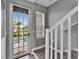 Bright entryway with a stylish staircase, a glass door and a view of palm trees at 603 Bahia Beach Blvd, Ruskin, FL 33570