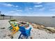 Relaxing waterfront spot with Adirondack chairs surrounding a stone fire pit, perfect for enjoying scenic views at 603 Bahia Beach Blvd, Ruskin, FL 33570