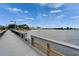 A scenic view of the pier leading towards the sandy beach and the tranquil water at 603 Bahia Beach Blvd, Ruskin, FL 33570