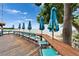 Inviting waterfront deck with tables, chairs and shade umbrellas overlooking stunning water views at 603 Bahia Beach Blvd, Ruskin, FL 33570
