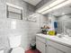 Bathroom with tiled walls, white vanity, and mirrored medicine cabinet at 9100 Suffolk Ln, Port Richey, FL 34668