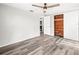 Spacious bedroom featuring wood floors, a ceiling fan, cedar closet, and ample natural light at 9100 Suffolk Ln, Port Richey, FL 34668