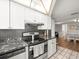 Well-designed kitchen with white cabinets, stainless steel appliances, and hardwood floors at 9100 Suffolk Ln, Port Richey, FL 34668