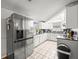 Modern kitchen with stainless steel appliances, sleek countertops, and neutral-toned tiled flooring at 9100 Suffolk Ln, Port Richey, FL 34668