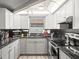 Modern kitchen with white cabinets, stainless steel appliances, and attractive backsplash at 9100 Suffolk Ln, Port Richey, FL 34668