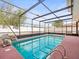 Screened pool with patio, waterfall feature and ladder at 9100 Suffolk Ln, Port Richey, FL 34668