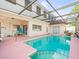 A backyard pool features a screened enclosure and space for outdoor lounging at 9100 Suffolk Ln, Port Richey, FL 34668