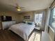 Bedroom with a large window, ceiling fan, television, and a bed with white comforter and blue pillows at 900 Harbour House Dr, Indian Rocks Beach, FL 33785