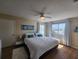 Bedroom with a large window, ceiling fan, and a bed with white comforter and blue pillows at 900 Harbour House Dr, Indian Rocks Beach, FL 33785