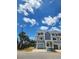 A light blue two-story townhouse with an attached garage on a sunny day at 900 Harbour House Dr, Indian Rocks Beach, FL 33785