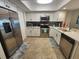 Well-lit kitchen featuring stainless steel appliances, white cabinetry, and a stylish backsplash at 900 Harbour House Dr, Indian Rocks Beach, FL 33785