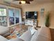 Cozy living room with sliding doors to the balcony and a decorative TV console at 900 Harbour House Dr, Indian Rocks Beach, FL 33785