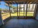 Relaxing screened-in porch offering views of the manicured lawn, tropical trees, and neighboring high-rise at 900 Harbour House Dr, Indian Rocks Beach, FL 33785