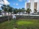 Street lined with palm trees, greenery, and view of the modern condo building at 900 Harbour House Dr, Indian Rocks Beach, FL 33785