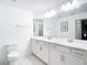 Bathroom with double sinks, large mirror, and a toilet at 14204 Heritage Landing Blvd # 714, Punta Gorda, FL 33955