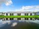 A row of modern condo units reflecting on a lake, complete with manicured lawns and community landscaping at 14204 Heritage Landing Blvd # 714, Punta Gorda, FL 33955
