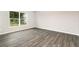 Bright bedroom features gray wood-look flooring and a window overlooking the green backyard at 3067 Newbury St, Port Charlotte, FL 33952