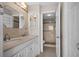 Well-lit bathroom featuring a dual vanity sink and tiled walk-in shower with mosaic accent at 3211 W Swann Ave # 808, Tampa, FL 33609