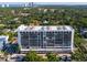 An exterior shot of the high-rise building situated among lush trees and parking at 3211 W Swann Ave # 808, Tampa, FL 33609