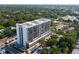 A high-rise building exterior view featuring surrounding greenery and parking at 3211 W Swann Ave # 808, Tampa, FL 33609