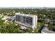 Stunning aerial view of a high-rise condominium building in a lush, green neighborhood near downtown with a water view in the distance at 3211 W Swann Ave # 808, Tampa, FL 33609