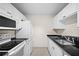 Functional kitchen showcasing white appliances, sleek black countertops, and ample cabinet space at 3211 W Swann Ave # 808, Tampa, FL 33609