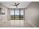 Bright living room featuring a ceiling fan and sliding glass doors to a balcony with city views at 3211 W Swann Ave # 808, Tampa, FL 33609
