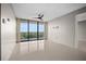 Bright living room featuring a ceiling fan and sliding glass doors to a balcony with verdant views at 3211 W Swann Ave # 808, Tampa, FL 33609