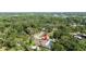 Aerial view of a property with a pool surrounded by lush greenery and mature trees at 4301 Hudson Ln, Tampa, FL 33618