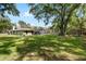 View of the expansive backyard with lush green lawn and screened pool at 4301 Hudson Ln, Tampa, FL 33618