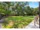Spacious backyard featuring a lush green lawn and a charming playset surrounded by mature trees at 4301 Hudson Ln, Tampa, FL 33618