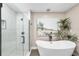 Modern bathroom featuring a stand-alone tub, walk-in shower, and beach themed decor at 4301 Hudson Ln, Tampa, FL 33618