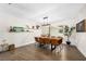 Bright and spacious dining room featuring stylish table with seating for eight, modern light fixture and views of the front yard at 4301 Hudson Ln, Tampa, FL 33618