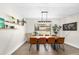 Bright and spacious dining room featuring stylish table with seating for eight, modern light fixture and views of the front yard at 4301 Hudson Ln, Tampa, FL 33618