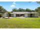 Inviting single-story home featuring manicured lawn, mature trees, and beautiful landscaping, providing great curb appeal at 4301 Hudson Ln, Tampa, FL 33618