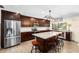 Modern kitchen boasts stainless steel appliances, an island with granite countertops, and dark wood cabinetry at 4301 Hudson Ln, Tampa, FL 33618