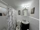 Cozy bathroom with a vanity cabinet, toilet, and shower with a white and grey marble patterned curtain at 29146 Tamayo Dr, Punta Gorda, FL 33982