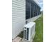 View of home exterior and air conditioning unit with white siding and brick foundation at 3124 Pond Hollow St # 183, Wesley Chapel, FL 33543
