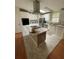 Bright kitchen with white cabinets, an island with cooktop, and stainless steel appliances at 3124 Pond Hollow St # 183, Wesley Chapel, FL 33543